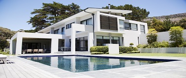 Modern house sitting on a hillside with a pool and landscaping