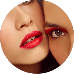 Two women wearing bright color cosmetics pose for the camera